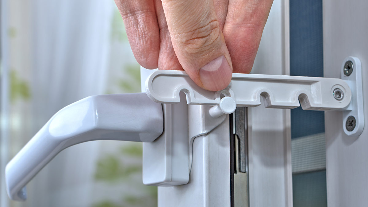 Ventana de aluminio forzada con marcas de palanca visibles junto al cierre del marco