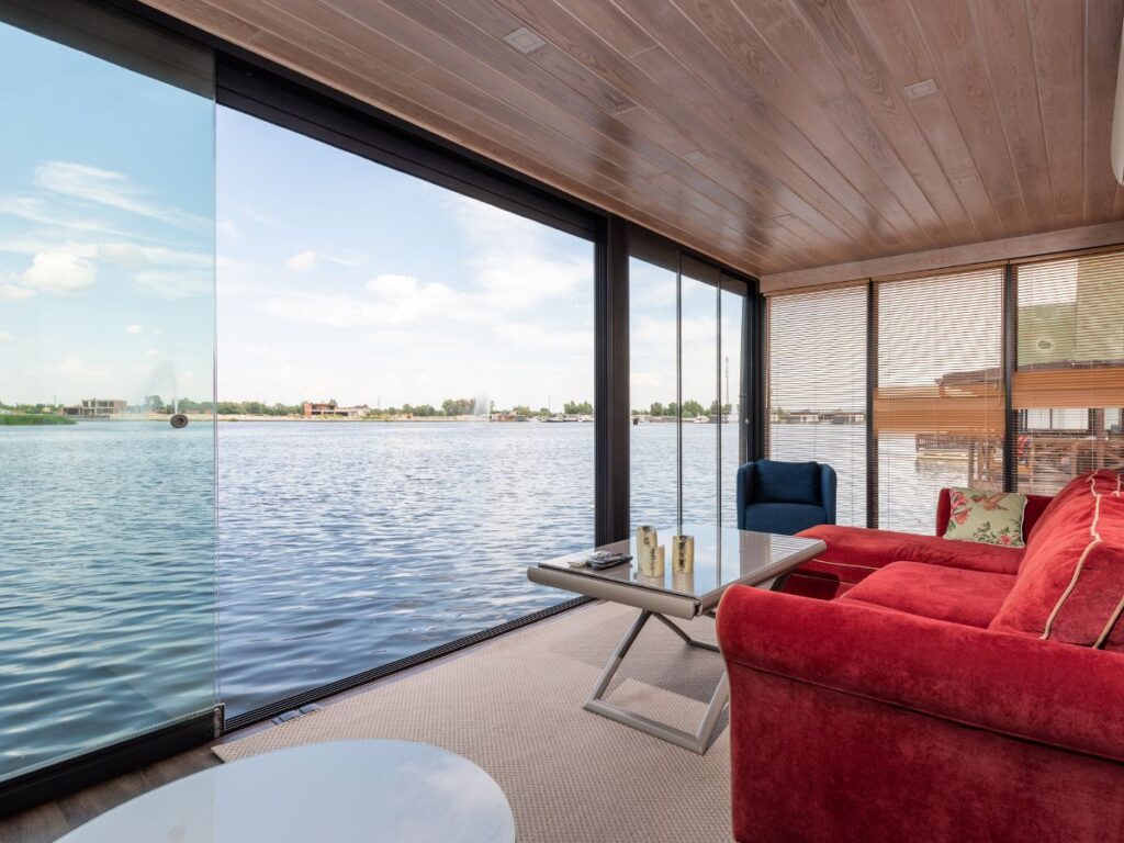 Habitación de hotel con gran acristalamiento y carpintería metálica en marco oscuro