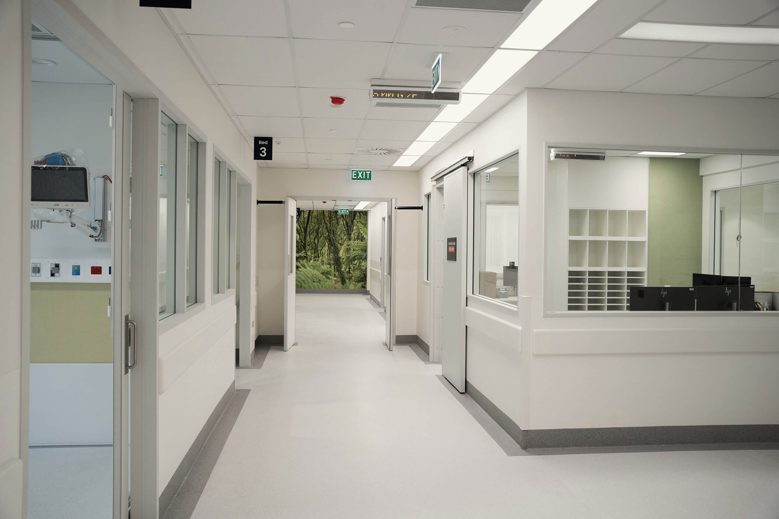 Pasillo clínico con puertas técnicas y acabados adaptados a uso sanitario
