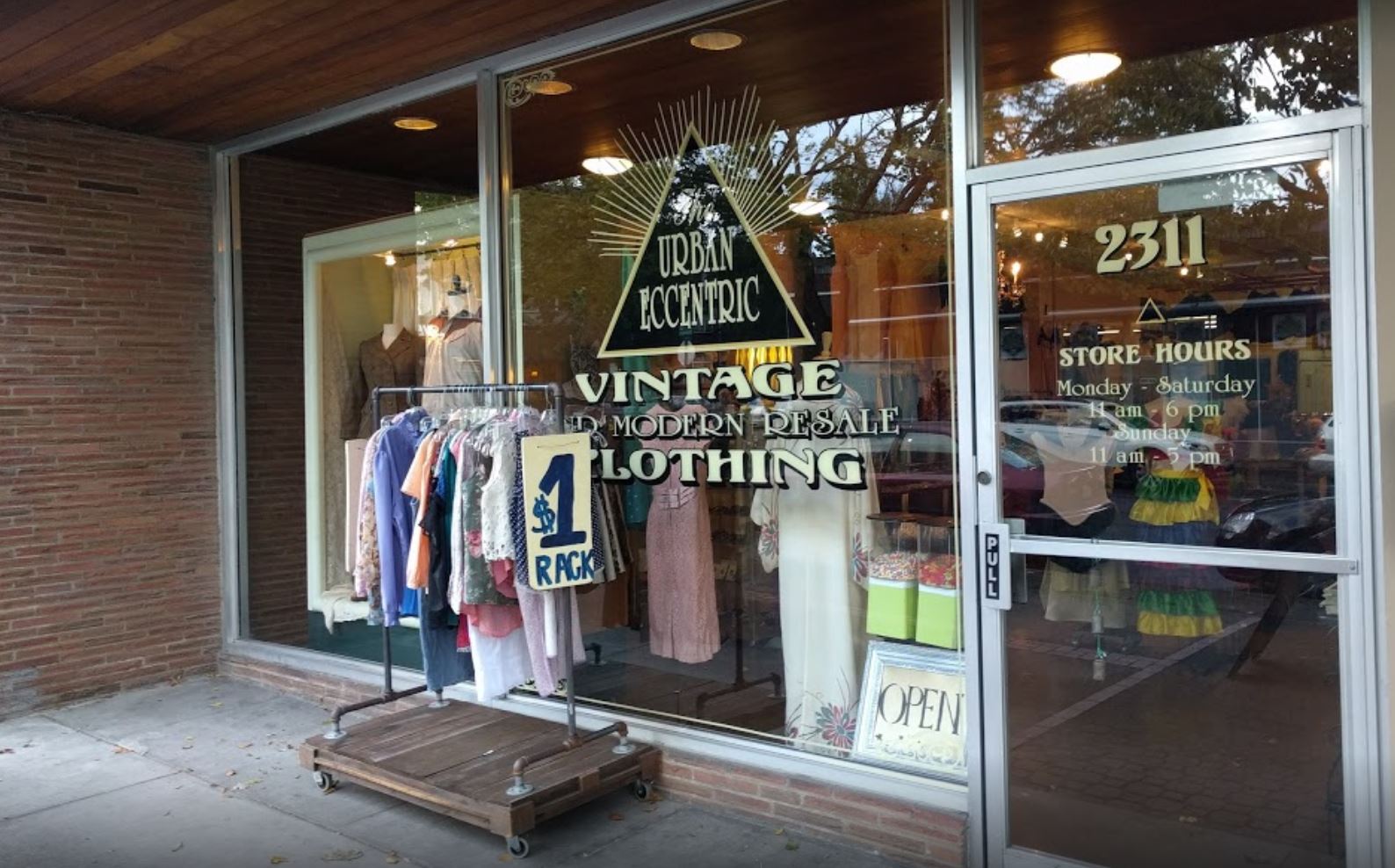 Entrada de tienda de streetwear con puerta amplia y perfilería reforzada de color oscuro
