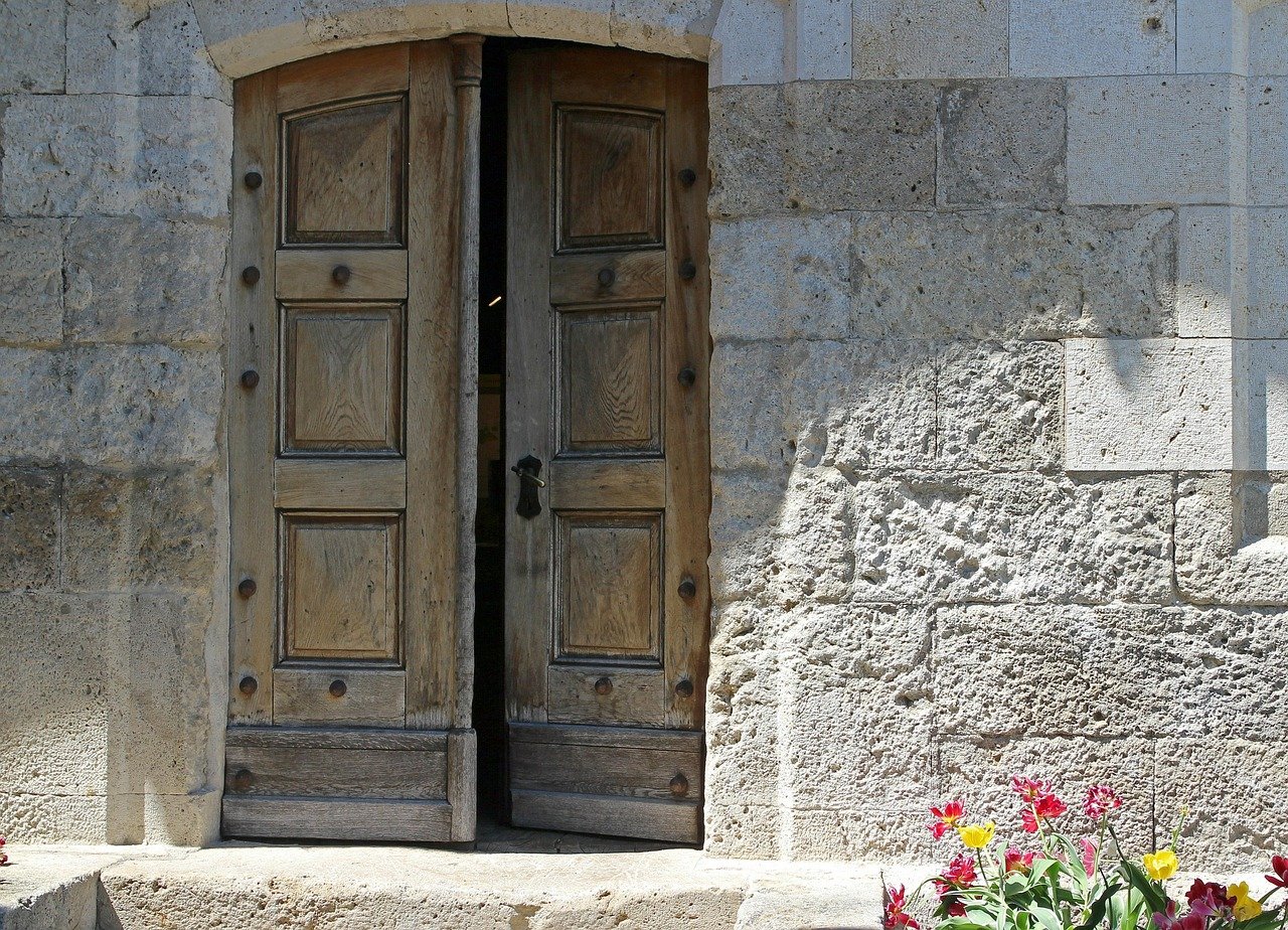 Acceso principal con acabado imitación madera en vivienda rural aislada