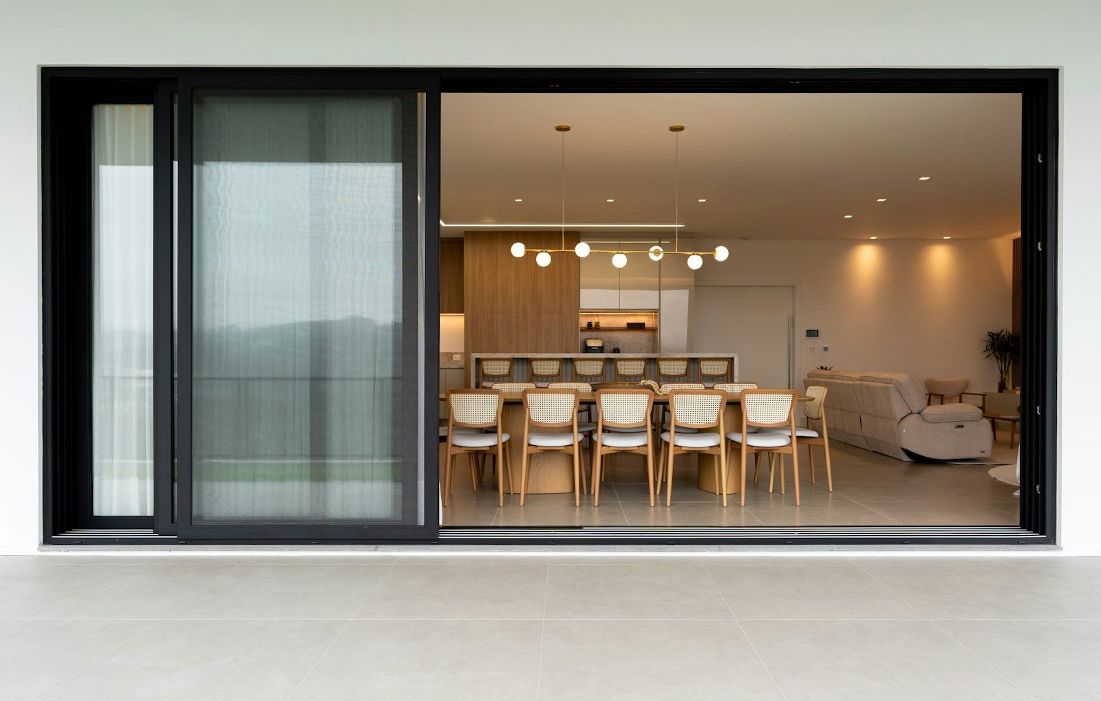 Corredera elevable de gran formato abierta hacia terraza en vivienda contemporánea